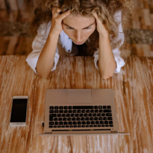 cloudflare woman looking upset in front of silver laptop